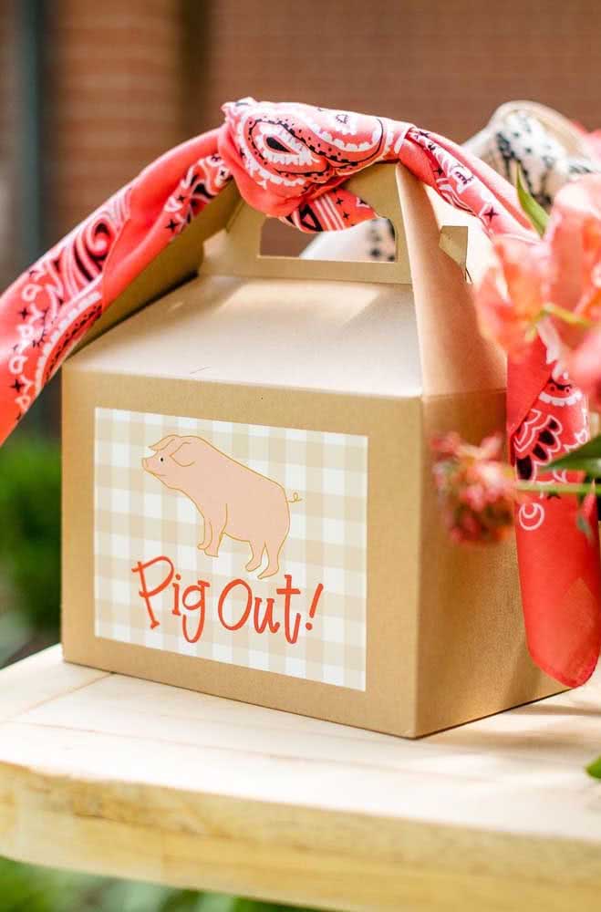 Lembrancinha caixinha de papelão com lenço vermelho e ilustração de porquinho.