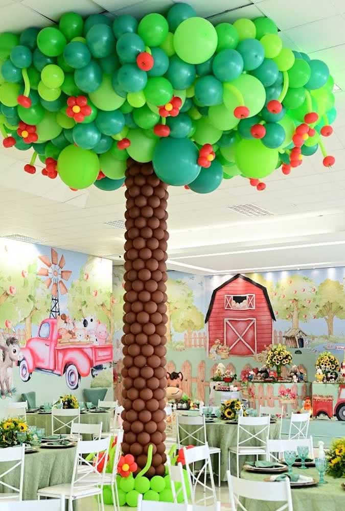 Aqui, a árvore de balões ganha um grande destaque no centro do salão da festa.