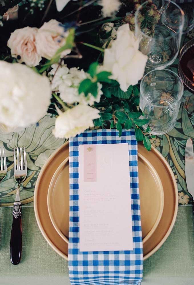 Guardanapo azul quadriculado em mesa que leva muito verde e natureza para dentro da festa.