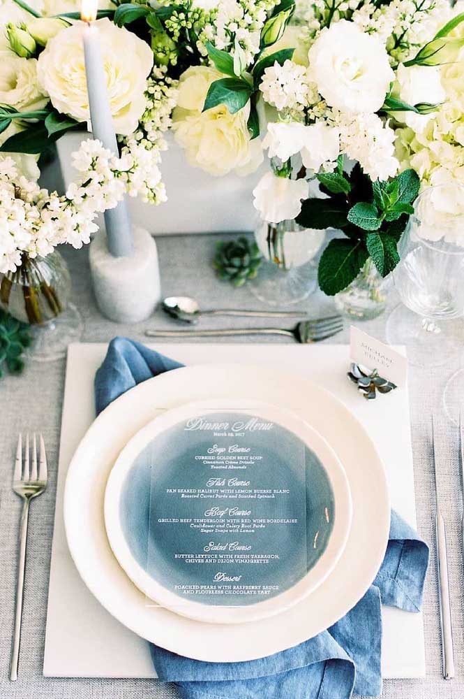 Detalhe do fundo do prato que leva a cor azul e o guardanapo na mesa dos convidados.