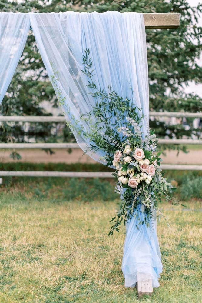 Tecido azul e arranjo floral para comemoração de casamento azul ao ar livre.