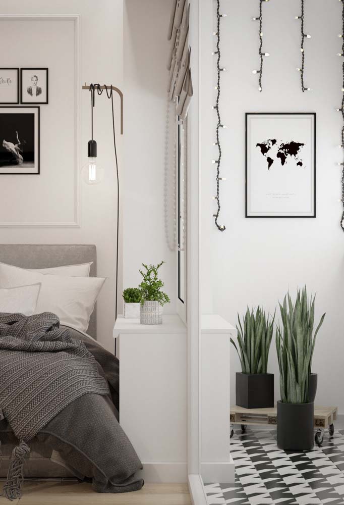 Trio de vasos pretos decoram a sala deste apartamento pequeno com decoração minimalista.