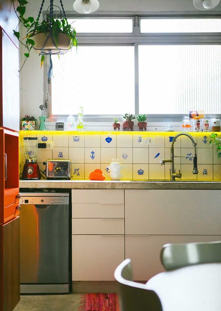 Azulejos retrô clássicos em cor clara na parede acima da bancada da cozinha.