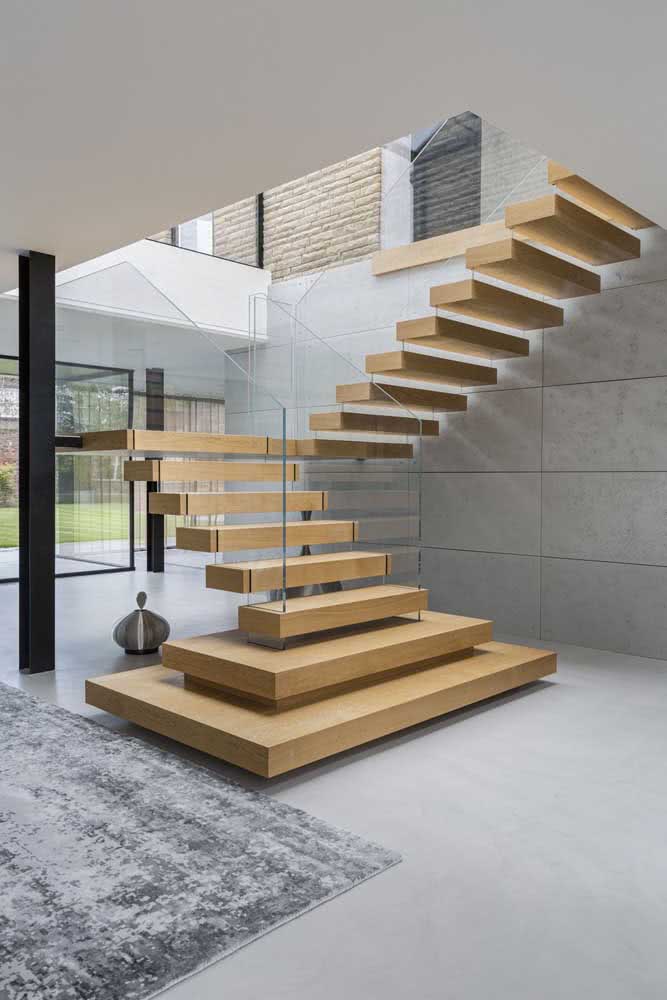 A casa moderna e elegante apostou na escada flutuante de madeira em tom claro