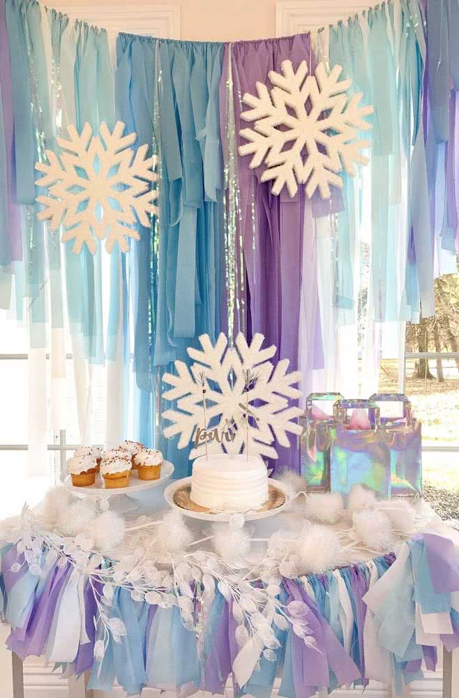 Mesa Frozen com o símbolo de gelo na mesa e nas fitas penduradas.