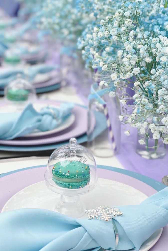 Mesa decorada com o tema da Frozen: lindos arranjos de pratos e flores.