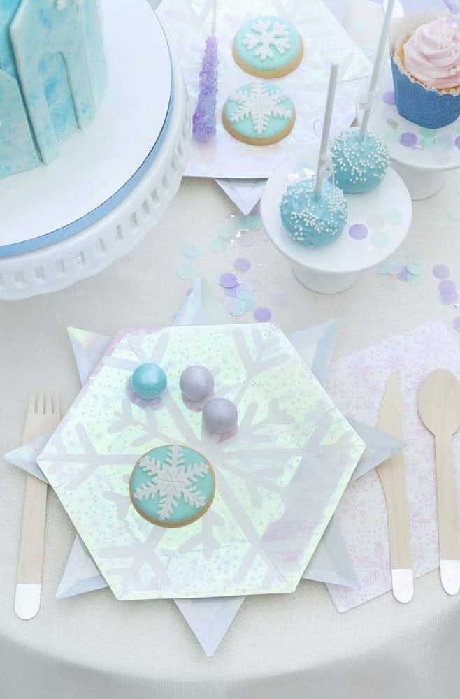 Detalhes da mesa com pratos prateados, doces azuis com o clima gelado do tema.