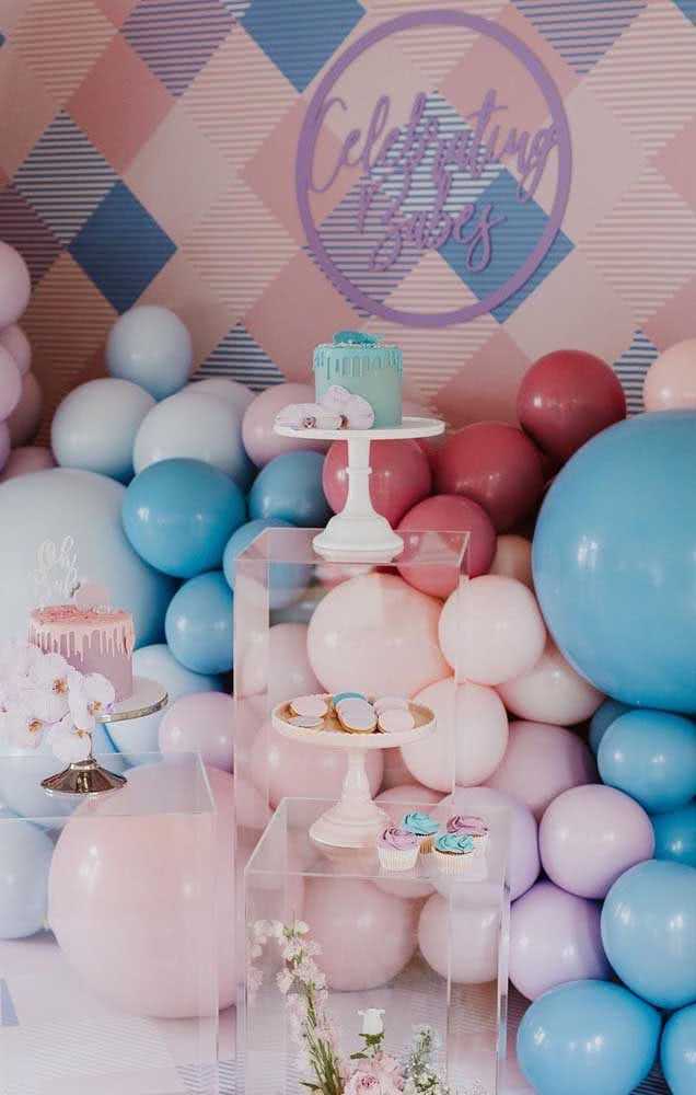 Aqui todos os bolos e doces foram dispostos em suportes de acrílico, dando foco para as cores dos balões que aparecem atrás.
