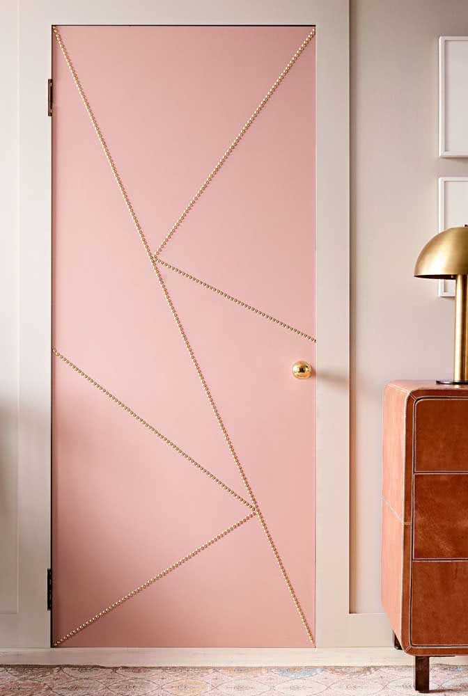E o que acha de uma porta de madeira cor de rosa com detalhes em dourado para o seu quarto?