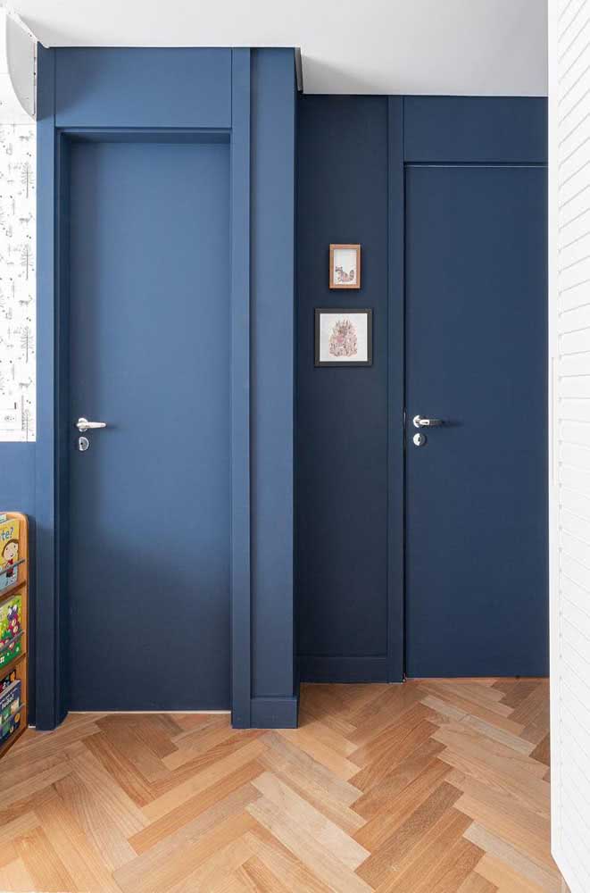 Portas azuis para combinar com a parede na mesma cor. O tom fechado ainda traz elegância e modernidade