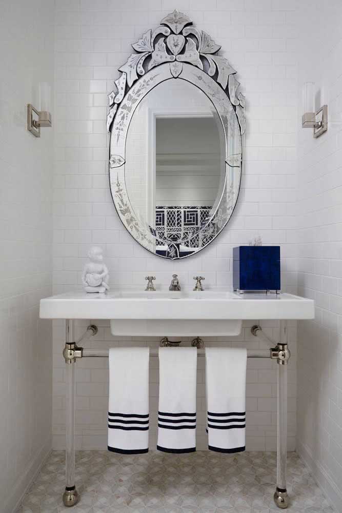 Espelho veneziano para quebrar a sobriedade do banheiro de azulejos brancos
