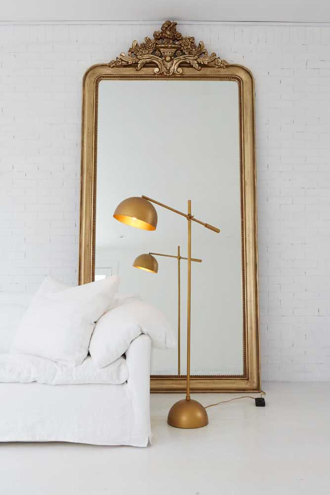 Espelho veneziano dourado trazendo brilho e cor para a decoração branca minimalista