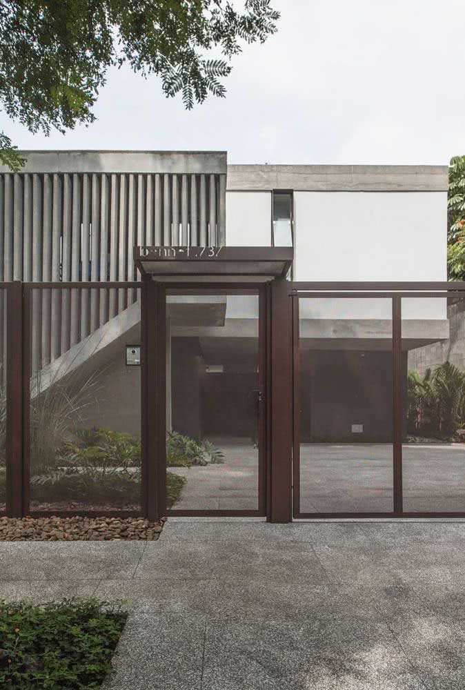 Modelo de portão vazado marrom com entrada de garagem e pequeno portão para visitantes.