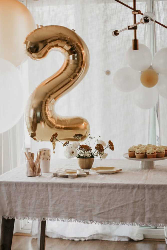 Decoração de festa com tema gold: balões e cupcakes são os protagonistas da mesa.