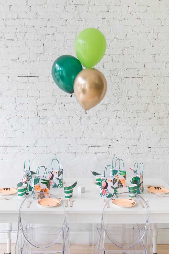 Decoração de festa infantil com tema verde e diferentes balões.