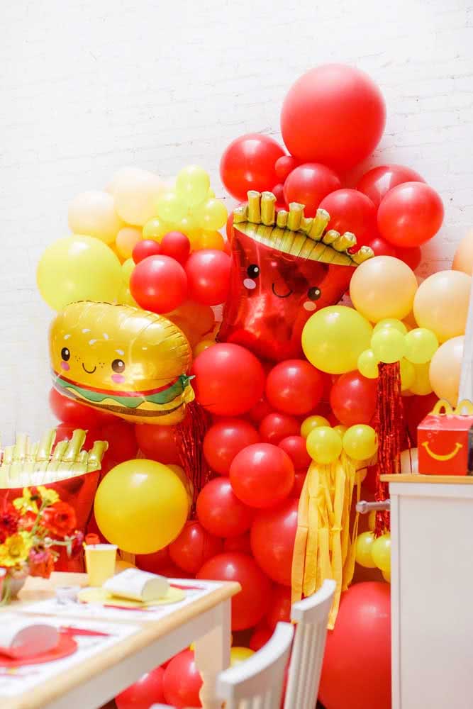 Festa com muitos balões vermelhos e amarelos.