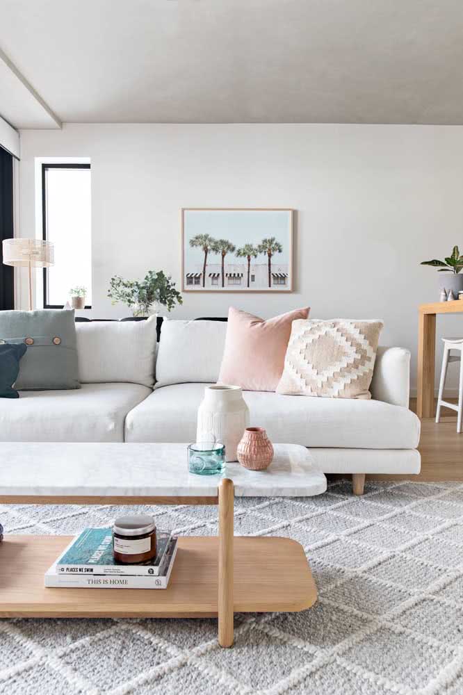 Sofá branco super confortável com almofadas coloridas em uma sala minimalista.