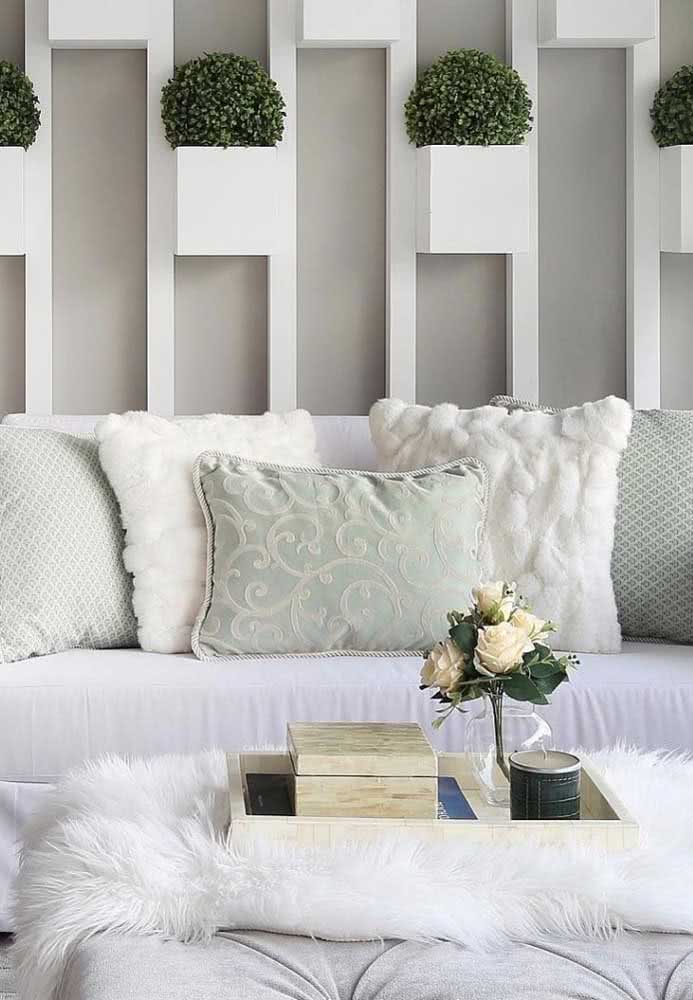 Modelo de sofá de tecido branco com diferentes estilos de almofadas.