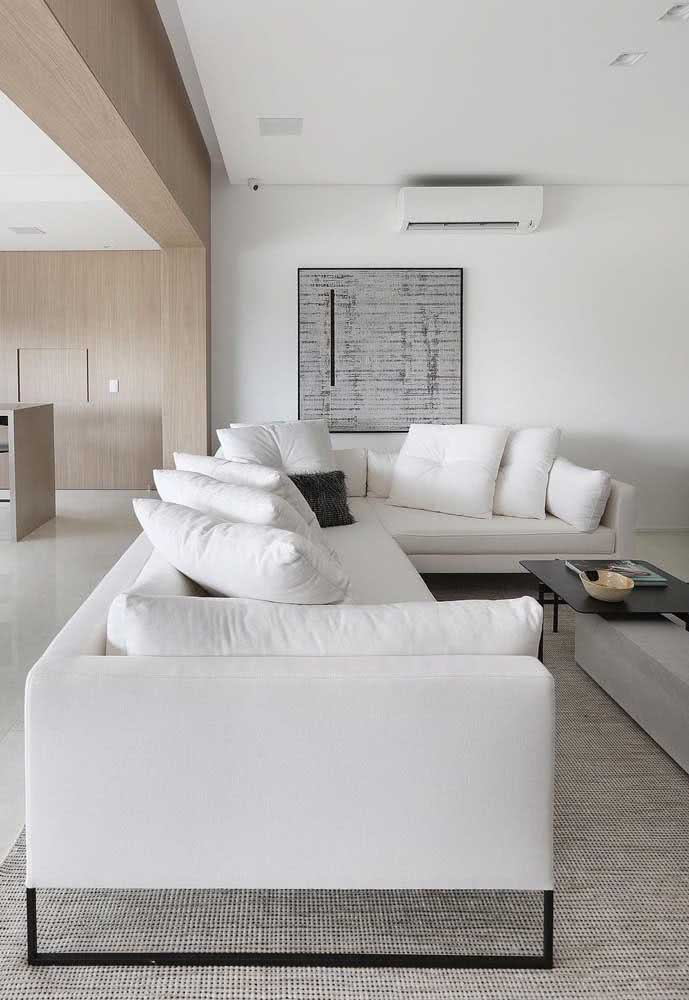 Sofá de tecido branco em L para sala de estar de apartamento.