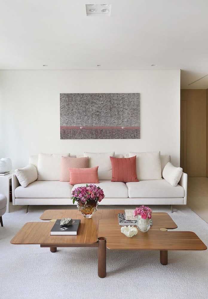 Sala simples, minimalista e delicadamente feminina com sofá branco.
