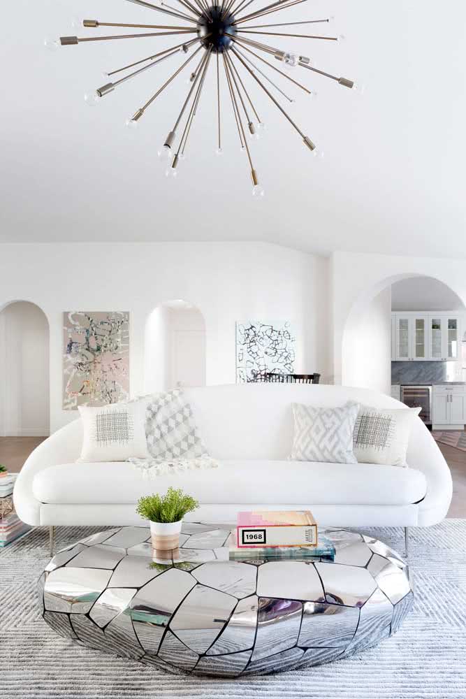 Sala descolada e moderna com sofá branco em formato diferenciado.