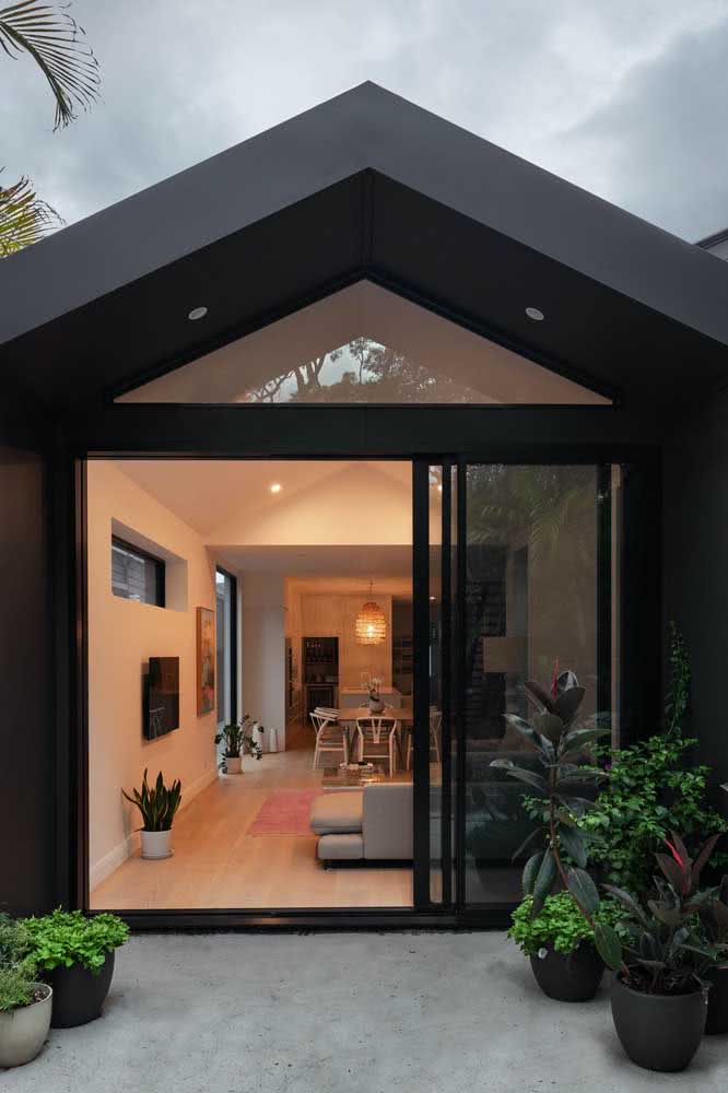 Um projeto diferenciado de fundos de casa térrea com telhado duas águas e pintura na cor preta.