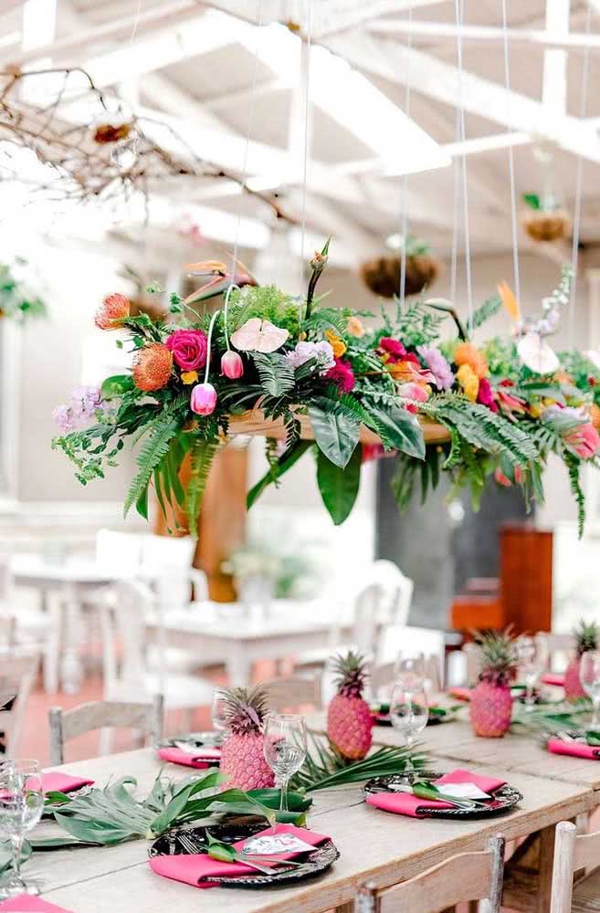 Ideia de decoração de mesa tropical com tons de verde e rosa.