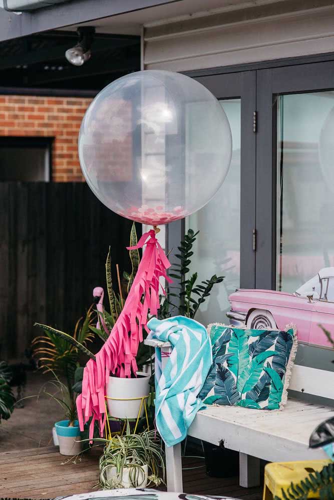 Cantinho com balão transparente e banco com almofadas personalizadas.