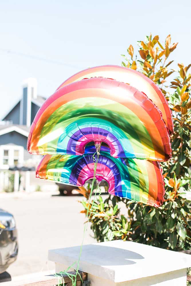 Trio de balões com formato e cores de arco-íris.