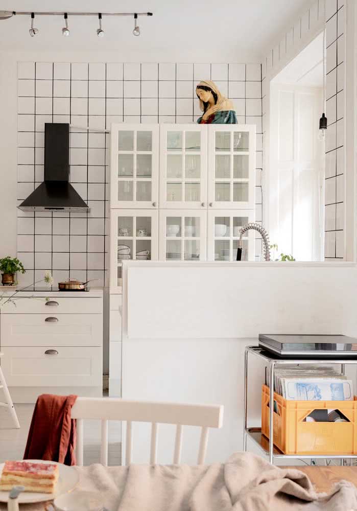 Cozinha simples com azulejos brancos e rejunte escuro.
