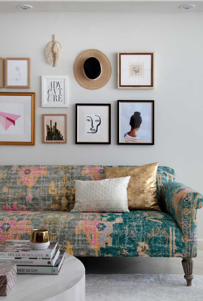 Decoração de sala com sofá estampado colorido. Os quadros na parede reforçam a atmosfera despojada do ambiente