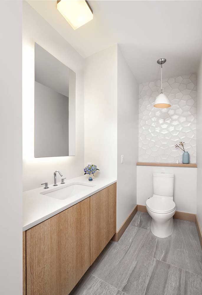 O banheiro branco e clean ganhou destaque com o espelho de led embutido