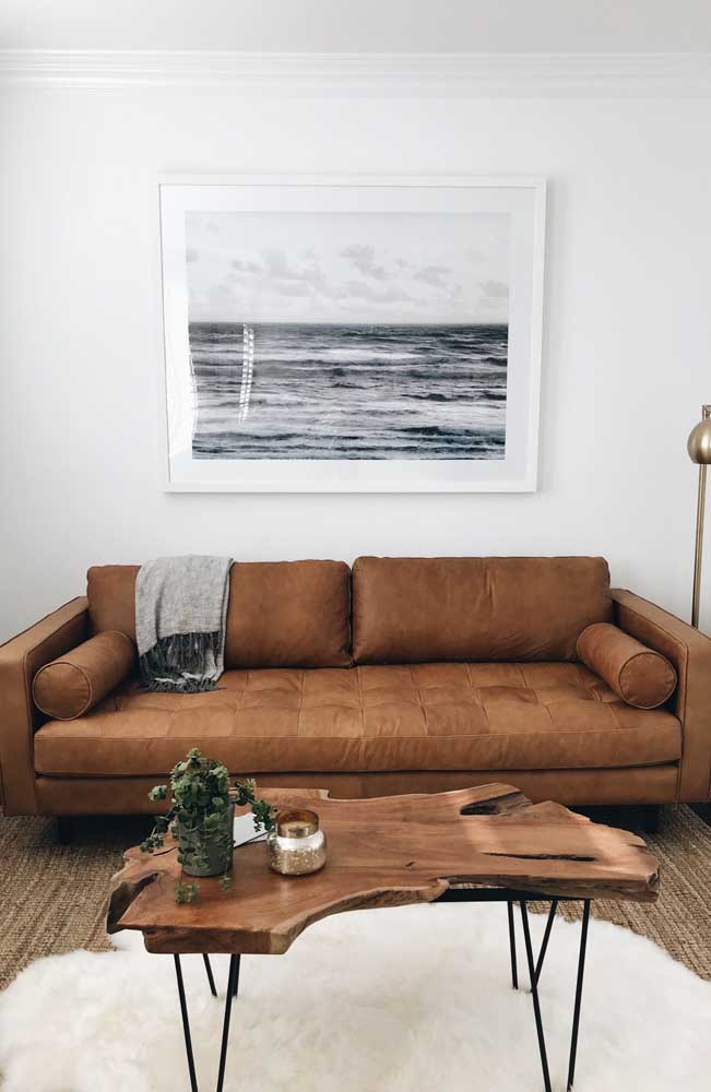 Mesa de madeira rústica na sala de estar seguindo a mesma tonalidade do sofá