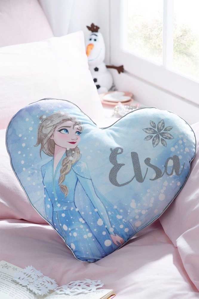 Sobre a cama, um cobre leito cor de rosa e uma almofada com estampa da personagem Elsa: simples e delicado
