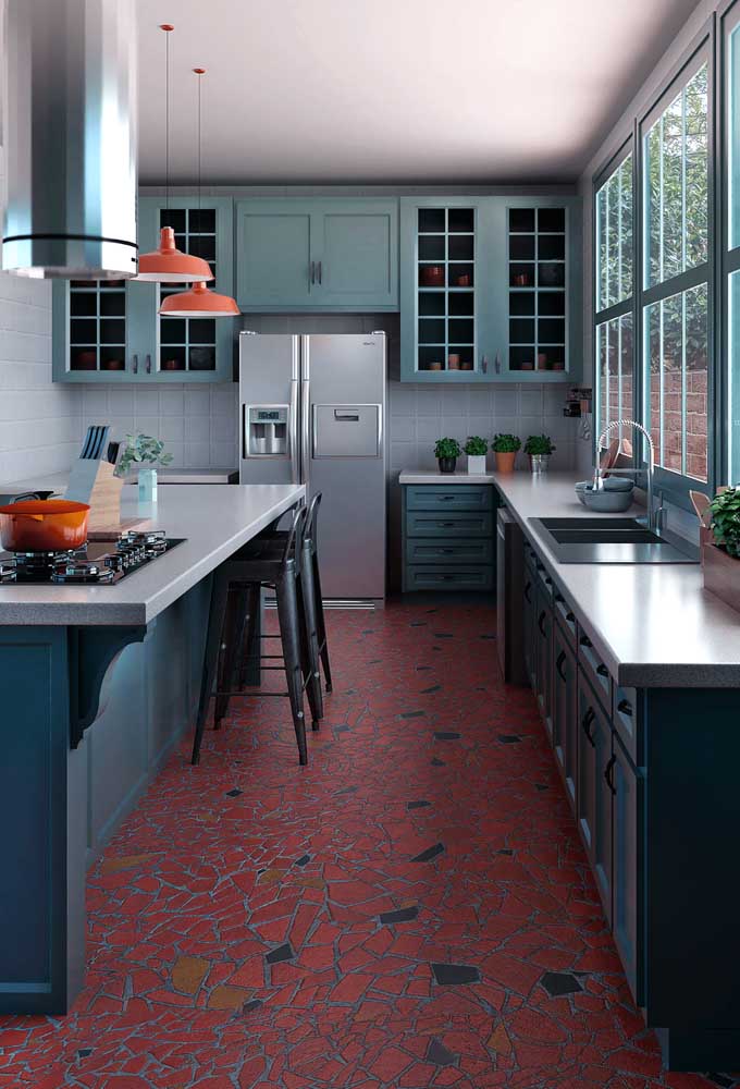 Nessa outra cozinha, o granito cinza foi usado de modo criativo em contraste com o piso vermelho