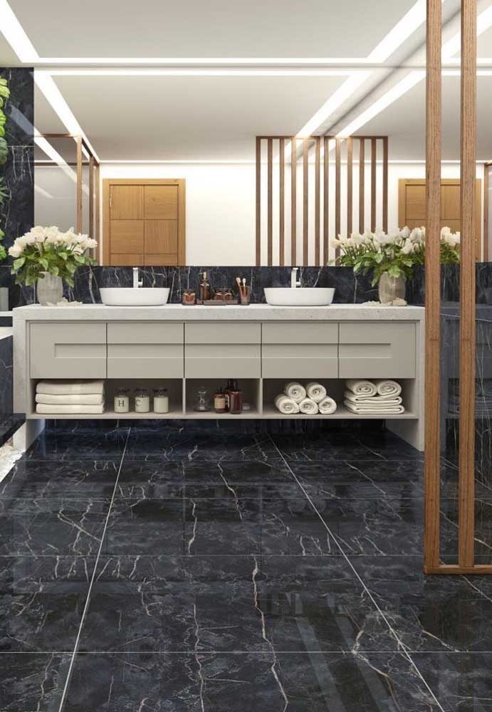 O banheiro amplo e espaçoso contou com o charme atemporal do porcelanato preto marmorizado 