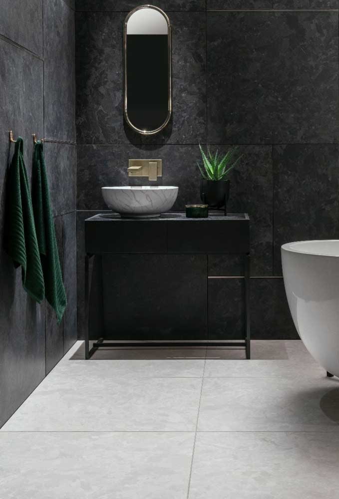 Já nesse projeto de banheiro, o porcelanato preto acetinado reveste as paredes