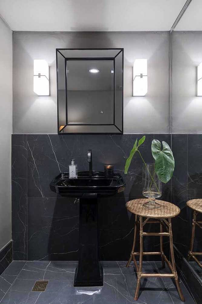Porcelanato preto marmorizado cobrindo apenas meia parede do banheiro