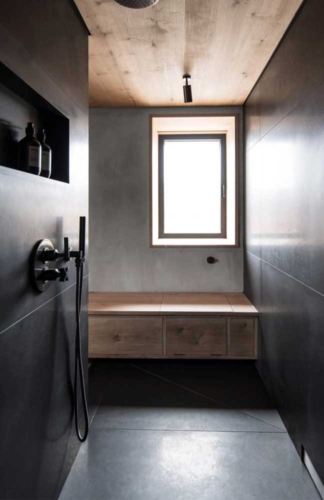 Garanta um toque a mais de conforto para o banheiro com porcelanato preto usando móveis de madeira natural