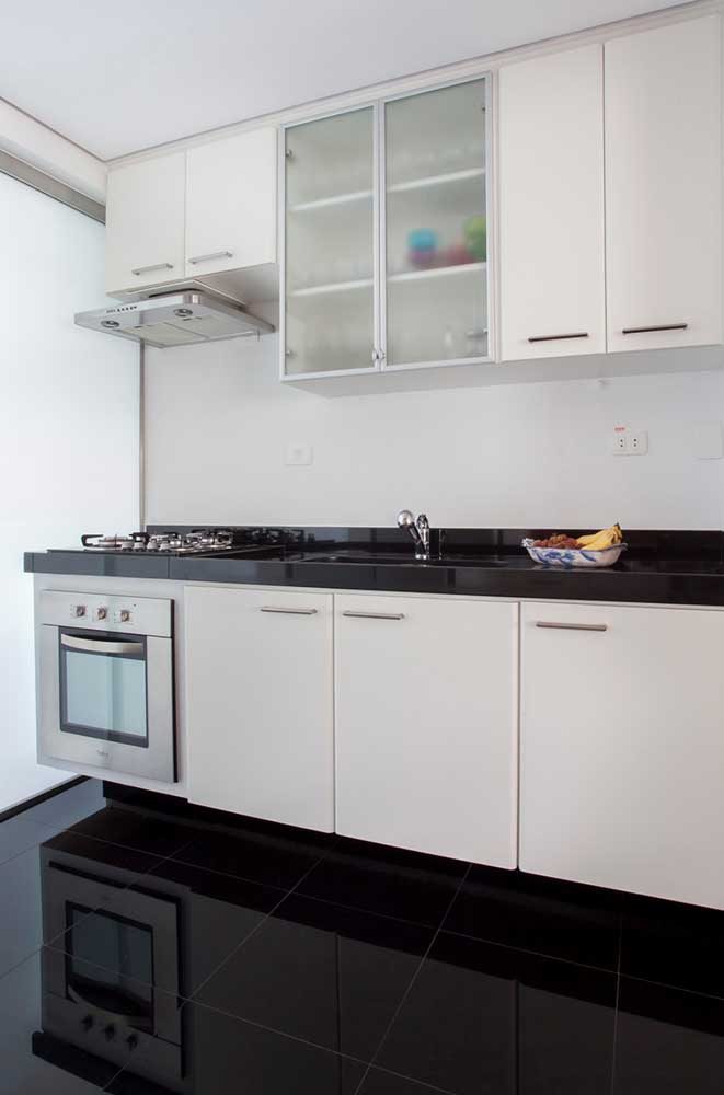 Projeto clássico e atemporal de cozinha: piso porcelanato preto com armários brancos