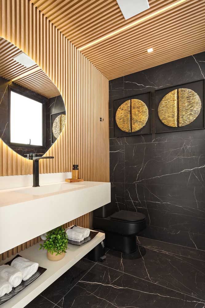 Que tal combinar o porcelanato preto marmorizado com um painel de madeira ripado no banheiro?