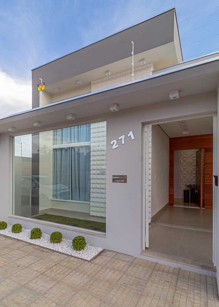 Vidros e cores neutras para uma fachada de casa popular moderna