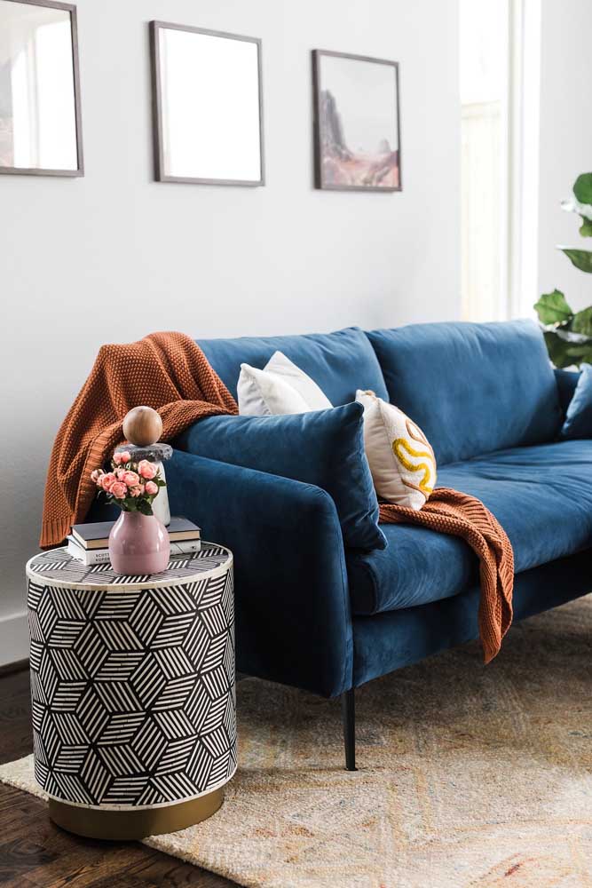 Sofá azul marinho em uma decoração de sala simples e pequena