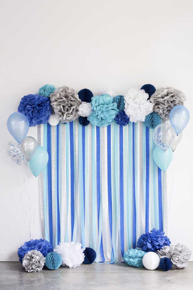 Cortina de papel crepom azul e branca. Os balões e as flores de papel garantem o toque final à decoração