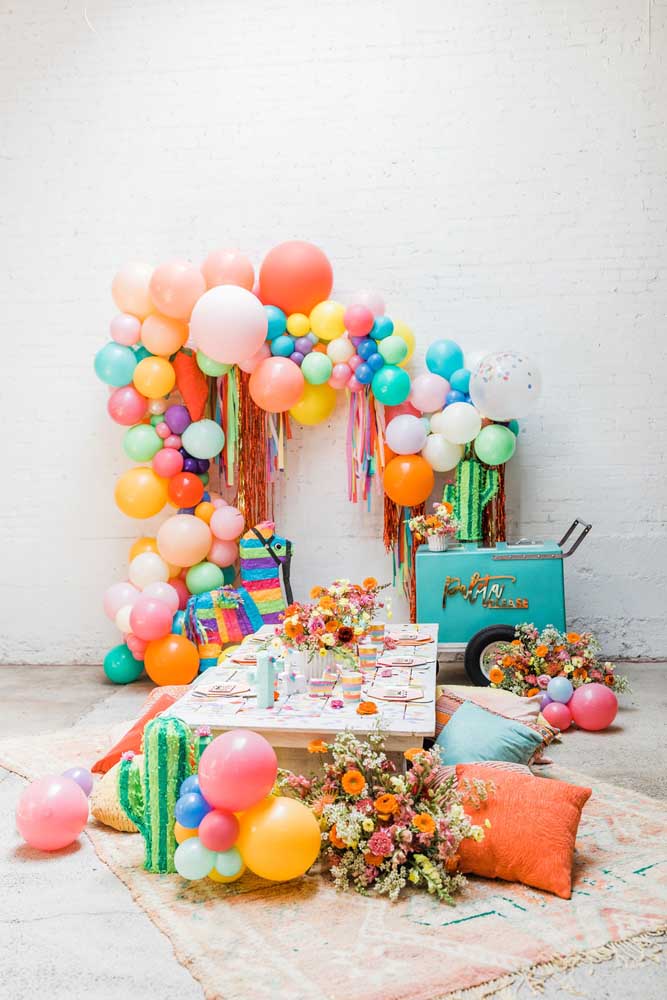Cortina de papel crepom com balões para um cenário de festa colorido e divertido