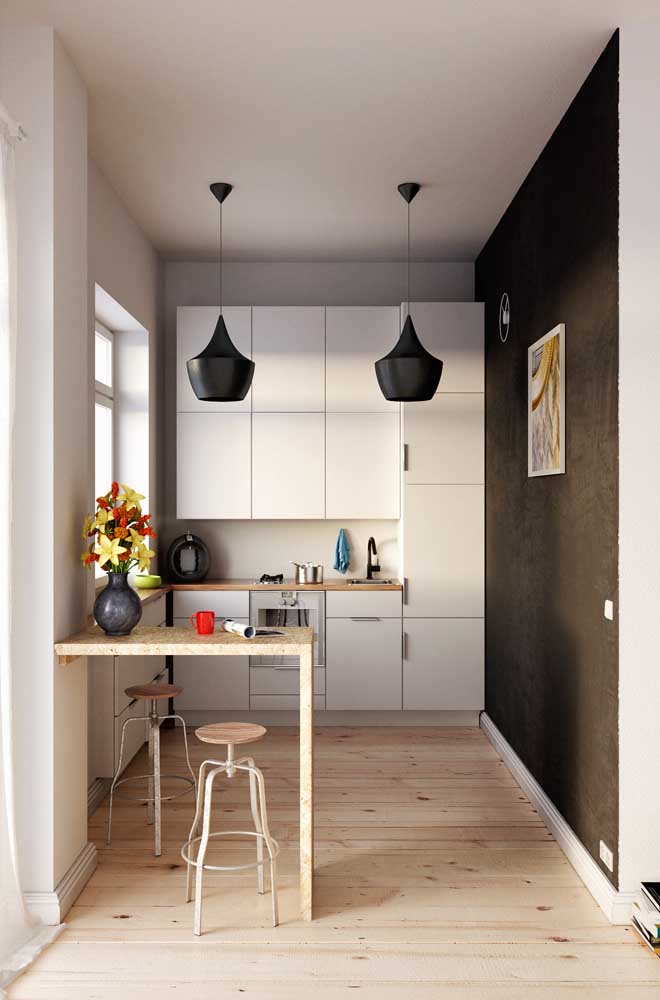 Já aqui, o duo clássico entre branco e preto ficou perfeito na cozinha planejada pequena e moderna 