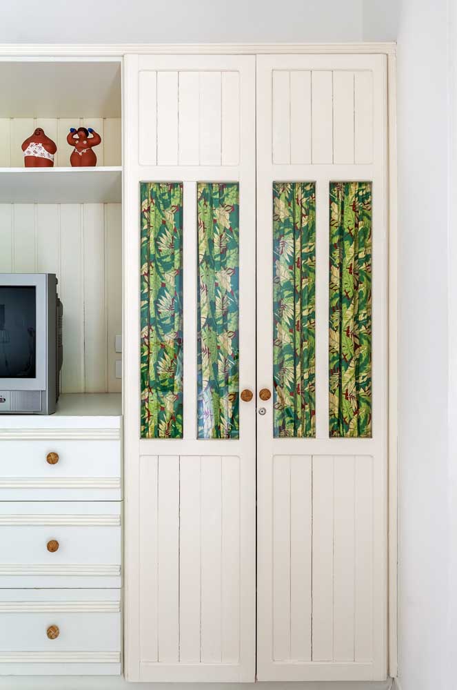 Uma cortina de tecido chita estampado para encobrir a portinha de vidro do armário. Um charme só!