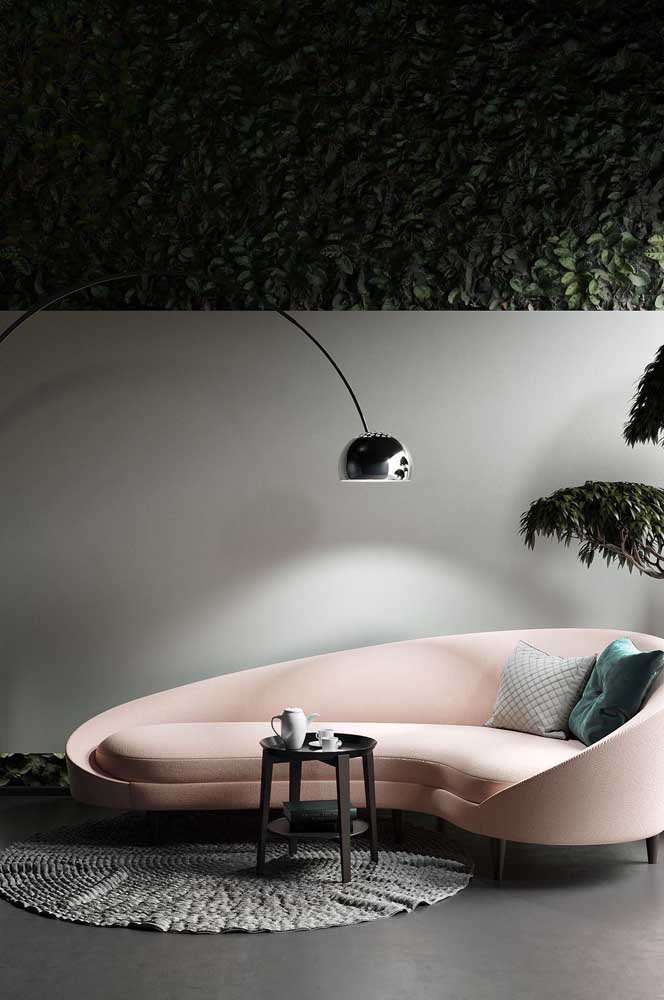 Sofá curvo de canto em tom de rosa claro, super moderno e combinando com a decoração minimalista