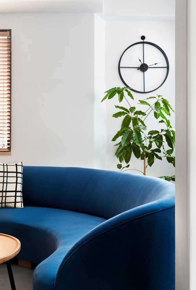 Para o sofá curvo aparecer, mantenha o restante do ambiente em cores claras e neutras