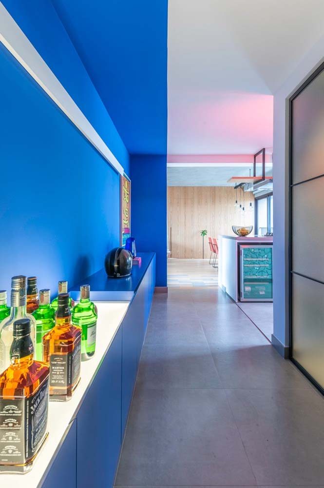 Cozinha extensa azul com parede de gesso lateral e superior